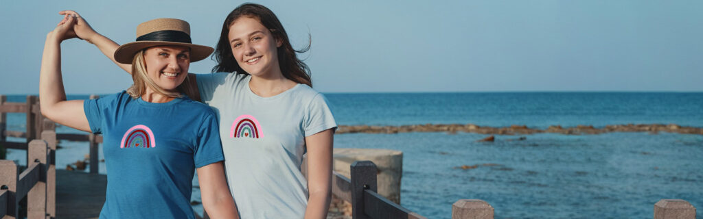 Twee vrouwen met regenboog T-shirts gemaakt van pearl glitter flex folie