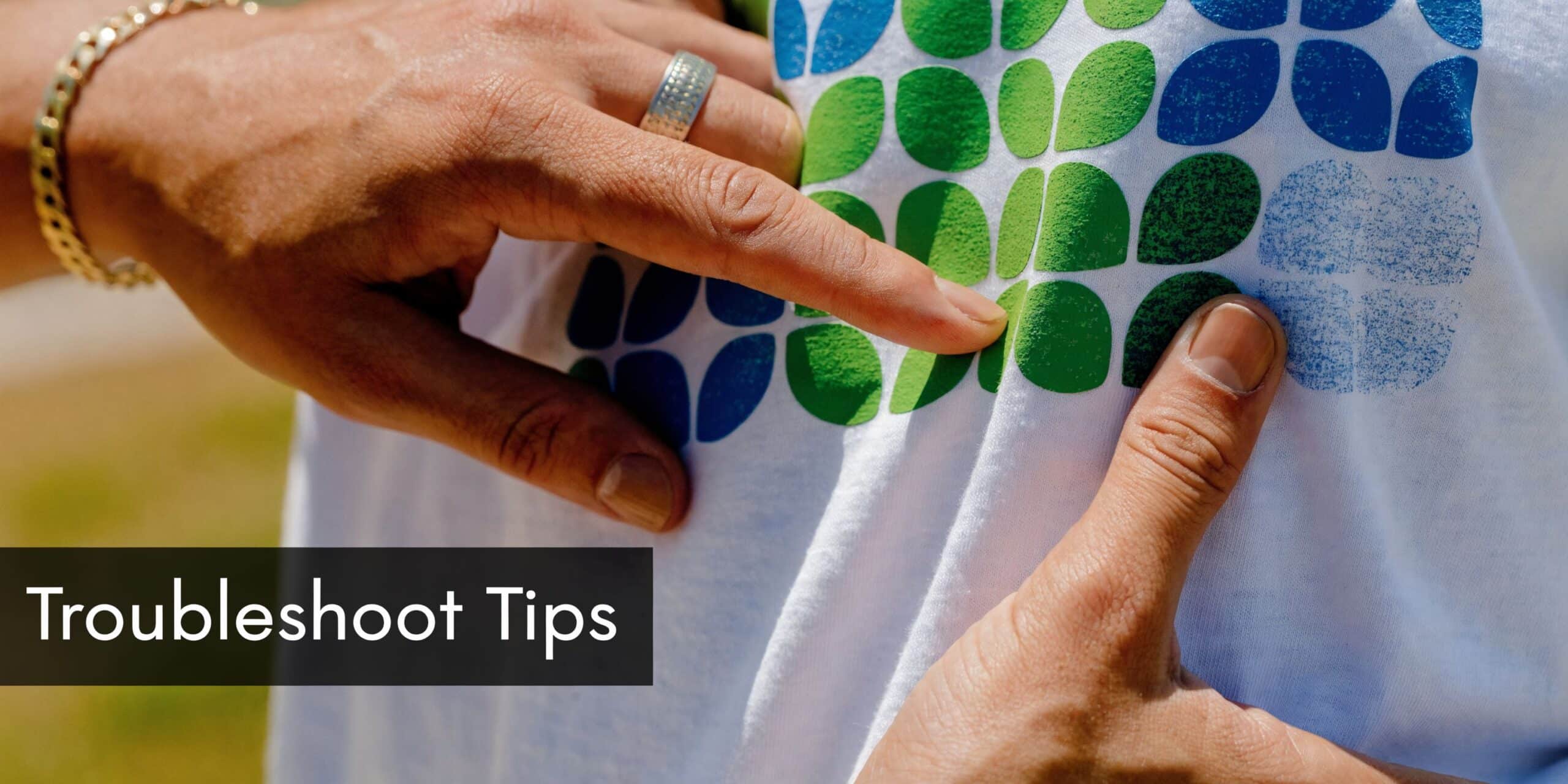 Een close-up van handen die de textuur van een puff flex print op een wit t-shirt voelen.